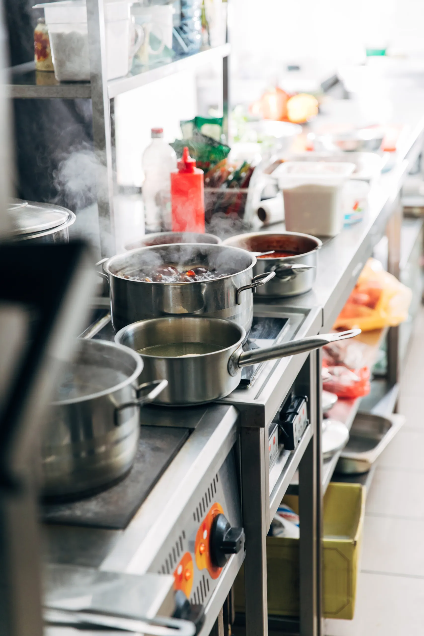 variation of dishes boiling in sauce pans at restaurant kitchen